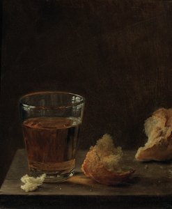 Un vaso de cerveza y un panecillo en una mesa