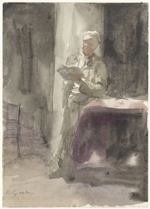 Hombre con un libro de pie junto a una mesa y una ventana