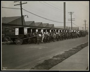 Carros de reparto tirados por caballos estacionados fuera de Carolyn Laundry en 111 East 128th Street, East Harlem, Nueva York, 1929 de Byron Company