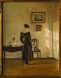 Un Interior con una Mujer Alimentando a un Gato de Carl Holsoe