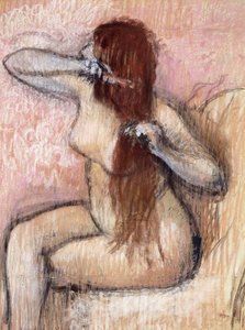 Mujer desnuda sentada arreglándose el cabello