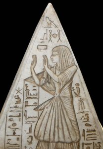 Pyramidion en piedra caliza colocado en la cima de las tumbas de las pirámides. Hay escenas grabadas que representan el ciclo solar y la adoración del sol por el difunto. Proviene de Deir el Medina