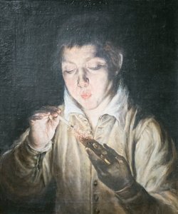 Niño soplando una brasa