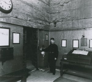 Un guardia de prisión junto a una puerta en el vestíbulo de entrada de English Photographer