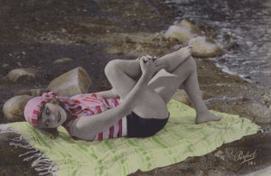 Chica tumbada en toalla en la playa