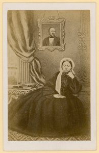 Reina Victoria, cuando era viuda, con un retrato del Príncipe Consorte detrás de ella de English Photographer