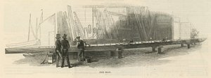 Dos hombres inspeccionando un nuevo bote en construcción de English School