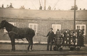 Portero con un carro de equipaje tirado por caballos en los muelles