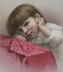 Niño de cabello castaño y grandes ojos escuchando el tic de un reloj de oro