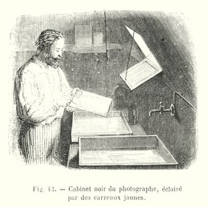 Gabinete negro del fotógrafo, iluminado por vidrios amarillos