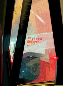 Cartel del Motel Rivera visto desde el coche en una noche lluviosa (arte digital)