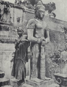 Joven monje budista novicio junto a una estatua de Buda, Indochina francesa de Ewing Galloway