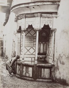 Un hombre bebiendo de una fuente de esquina, en una calle de Damasco, Siria de Félix Bonfils