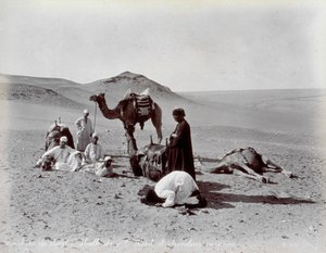 Camelleros egipcios durante una pausa en el desierto. En primer plano, dos miembros del pequeño grupo parecen estar rezando