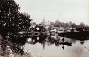 La ciudad de Ross-On-Wye, vista desde una orilla del río. En primer plano un hombre de pie en un bote de remos