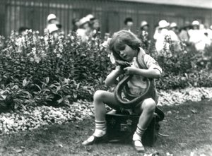 Una niña, Betty, sosteniendo una serpiente índigo oriental, sentada en un baúl de cuero, Zoológico de Londres, 1924 de Frederick William Bond
