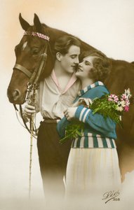 Pareja a punto de besarse, de pie junto a un caballo marrón de French Photographer