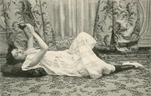 Niña, acostada en el suelo, sosteniendo una pelota sobre su cabeza de French Photographer