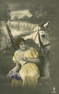 Niña sentada en el sofá con caballo blanco detrás