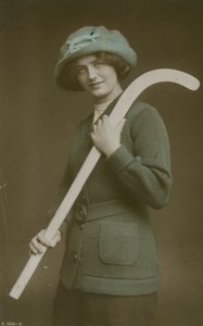 Joven mujer llevando un palo de hockey sobre su hombro de French Photographer