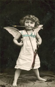 Niño pequeño, vestido como Cupido, con una flecha en la boca