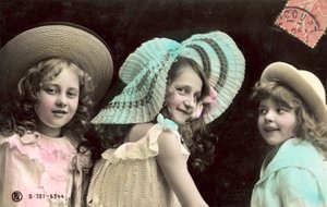 Tres niñas jóvenes con sombreros, sonriendo