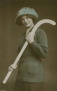 Joven mujer llevando un palo de hockey sobre su hombro