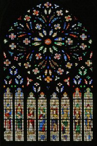 Ventana w237, el rosetón oeste, que representa el Cordero del Apocalipsis (C20) en el centro rodeado por 12 ángeles músicos; escudos de armas que incluyen Montmorency-Laval, Bertrand Duguesclin y Oli de French School