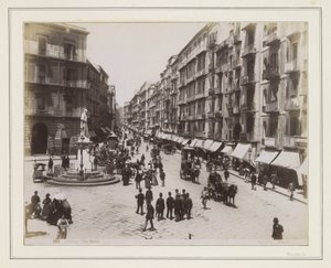 Vista de la Via Roma en Nápoles, con una estatua, tiendas, carruajes tirados por caballos y transeúntes de Giorgio Sommer