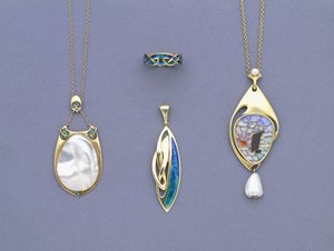Un grupo de colgantes y un anillo de metal amarillo y esmalte de Liberty & Co diseñados por Archibald Knox de Giovanni Bigatti