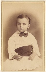 [Niño sin identificar con pajarita, sentado]