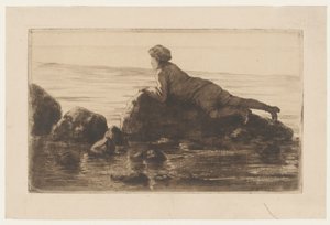 Niño tumbado en las rocas de la playa