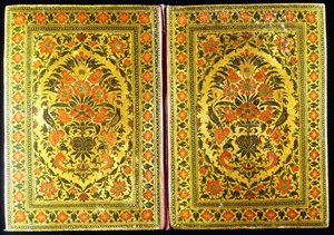 Un par de cubiertas de libros lacadas decoradas con un diseño floral, con un jarrón de flores y pinzones en el centro de Indian School
