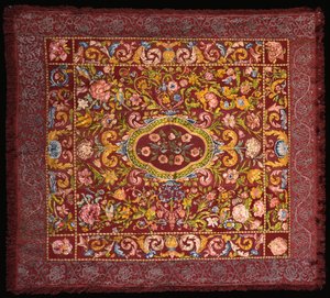 Una alfombra de mesa italiana bordada con sedas de colores brillantes con un medallón central de rosas dentro de un campo de lirios y flores más grandes de Italian School