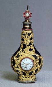 Frasco de perfume con reloj y brújula