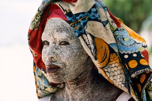 Una mujer lleva mussiro de crema de corteza de tierra para protegerse la cara del sol. Mocambiq...