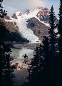 Caballo solitario y jinete reflexionan sobre un lago al pie del pico más alto de Canadá. Monte Robson... de James L Stanfield