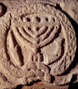 Judaísmo: elemento arquitectónico en basalto de una sinagoga decorado con un candelabro de siete brazos (Menorá o Menorah), palma y trompeta. De Transjordania. Alrededor del año 100 d.C. París, Museo del Louvre de Jewish School