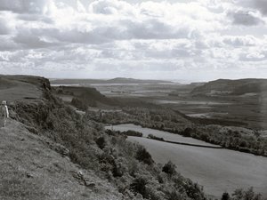 Una señora de pie en una ladera mirando a través del paisaje en Scout Scar de Joseph Hardman