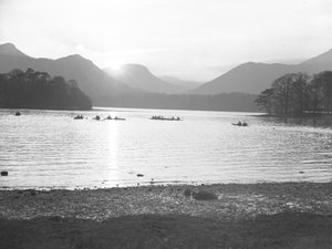 Vista de la gente navegando en canoa en Derwentwater al amanecer o al atardecer