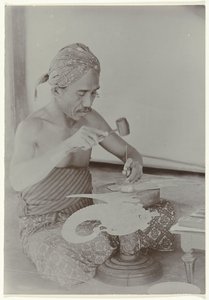 Hombre javanés usa martillo e instrumentos para crear una imagen que se asemeja a una figura humana