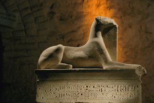 Estatua de piedra caliza del dios chacal Anubis agazapado sobre una base en forma de sarcófago..., 2002 (foto)
