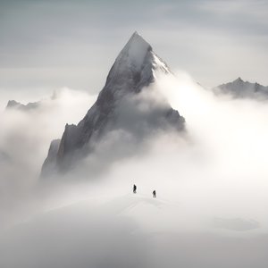 dos personas esquiando sobre una montaña nublada 3
