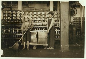 Ronald Webb de 12 años y Frank Robinson de 7 años, hijo del jefe de cardado, que barre y despeja (limpia bobinas llenas) en Roanoke Cotton Mills, Virginia, 1911 de Lewis Wickes Hine