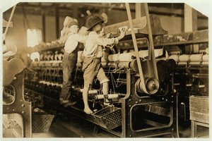 Niños pequeños trepando en el marco giratorio para arreglar hilos rotos y reemplazar bobinas vacías en Bibb Mill, Macon, Georgia, 1909 de Lewis Wickes Hine