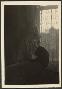 [Niña apoyada en el respaldo de la silla]
