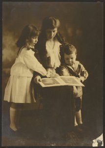 [Mujer y niños con libro ilustrado]