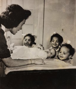 La enfermera Henry Street asiste a tres niñas afroamericanas en Harlem, Nueva York de Luigi Leoni