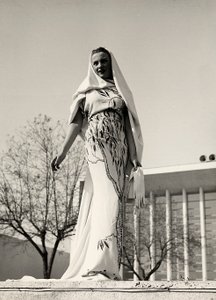 Modelo con vestido de noche de tela estampada floral, creado por la casa de alta costura "Lamma". El artículo se completa con un largo velo.