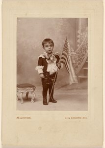 [Niño de pie, sosteniendo una bandera americana]